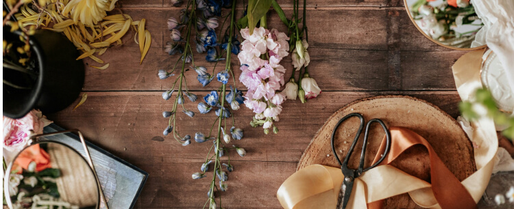 mesa rustica con flores, sombreros, tijeras y decoracion